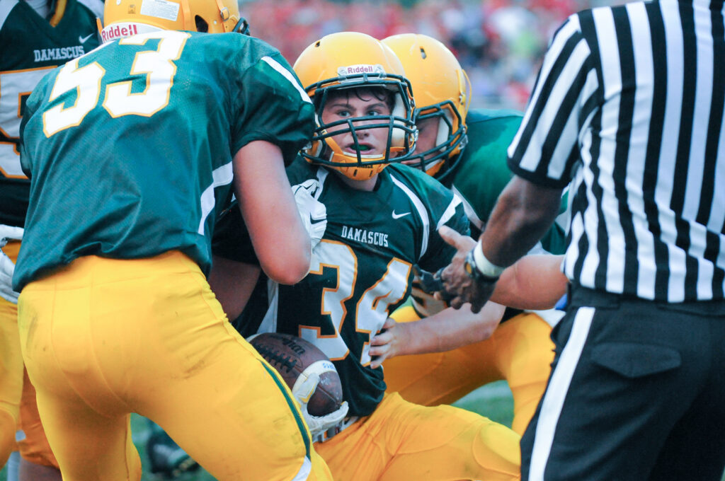 photo of Jake Funk being helped up by his brother #53