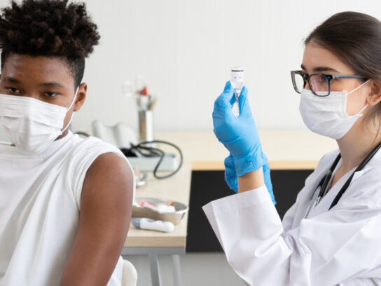 photo doctor preparing to give student vaccine