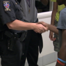 photo of school resource officer shaking hands with student