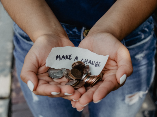 photo of hands holding change with note saying make a change