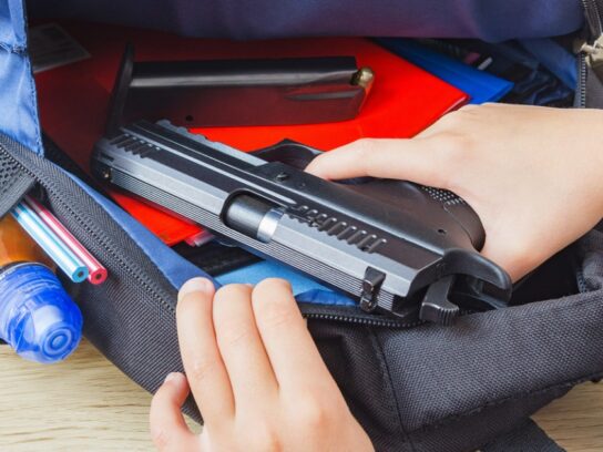 photo of student backpack open with a gun