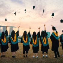 photo of graduates throwing caps in the air