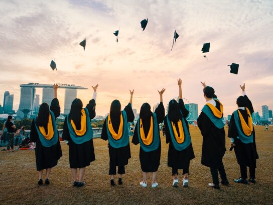 photo of graduates throwing caps in the air