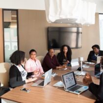 photo of adults at meeting with laptops