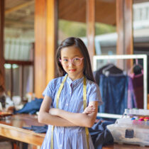 photo of young teen in charge of dress making workshop