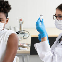 photo doctor preparing to give student vaccine