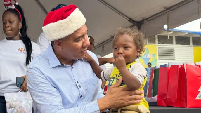 Prime Minister, Dr. the Most Hon. Andrew Holness interacts with a young child at a Christmas kiddies treat at the Middle Quarters Primary and Infant School in St. Elizabeth, on December 13.