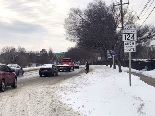 Main highways are clear, but many bus stops remain covered in snow, forcing riders to wait along the roadway.