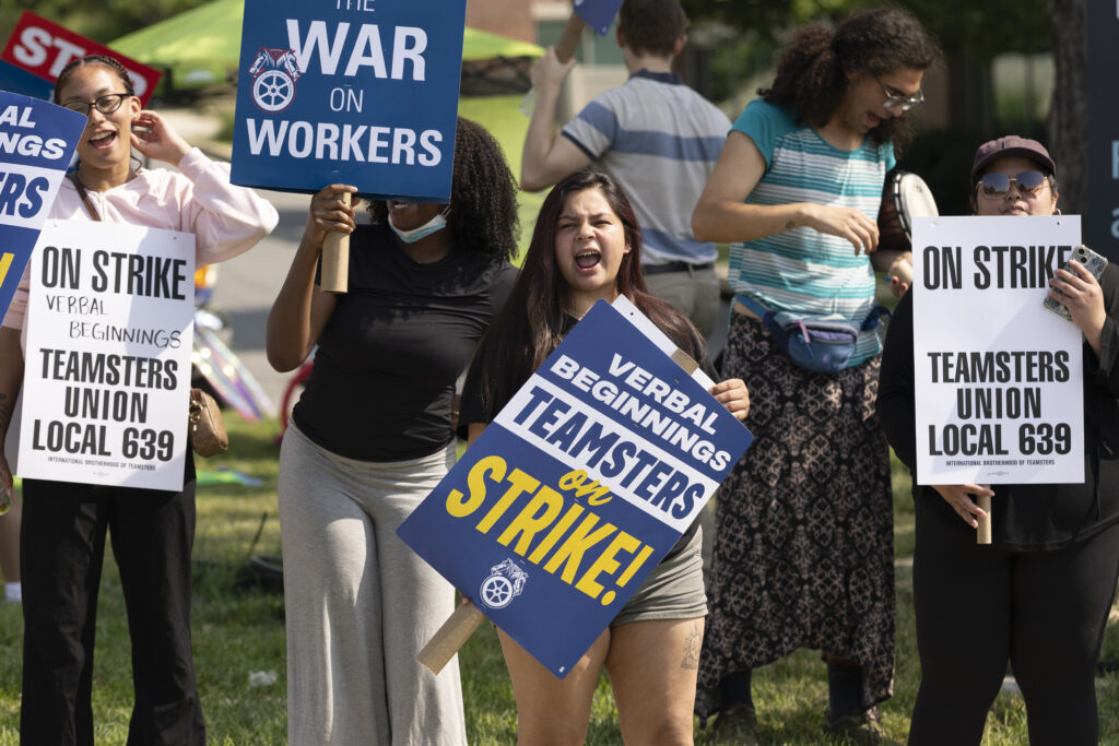 Striking workers chant and hold signs outside Verbal Beginnings.