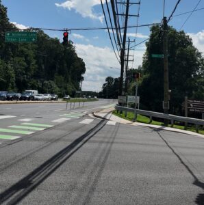 Street signs for Nicholson Lane and Tilden Lane along Old Georgetown Road showing the green protected bike lane.