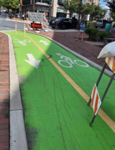 Green bike lane on Woodmont Avenue in downtown Bethesda with arrows pointing in opposite directions and a road closed sign.