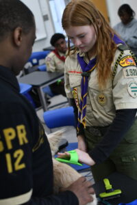 A Scout in uniform works with an Alpha Phi Alpha member during a veterinary medicine merit badge class at Alpha Merit Badge University.